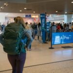 woman on an airport carrying travel backpack