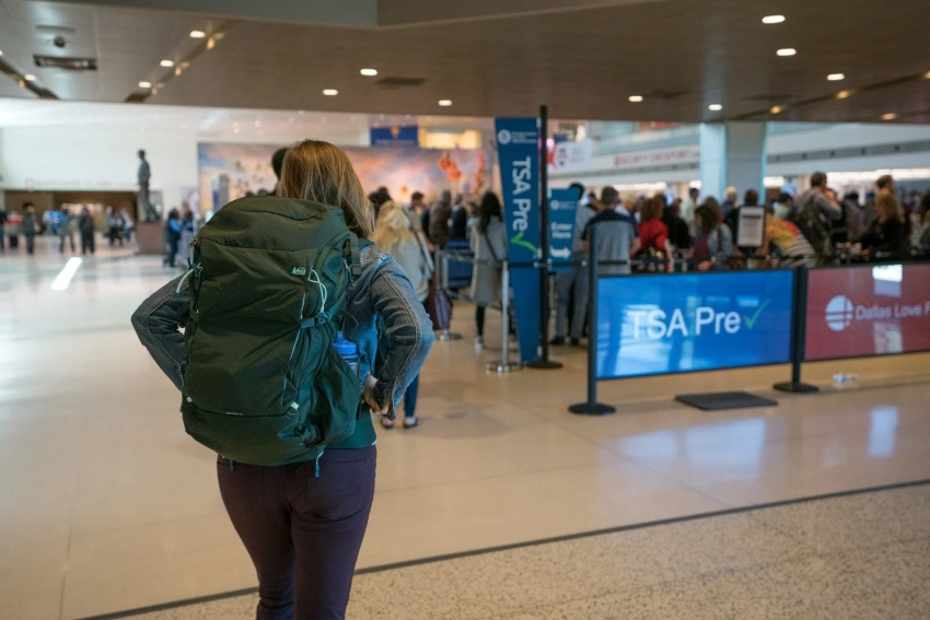 woman on an airport carrying travel backpack